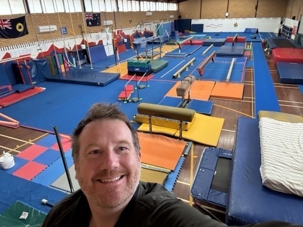 Andrew in front of a gymnastics setup.